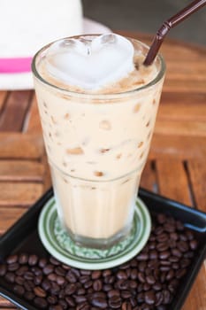 Cold glass coffee with milk and heart ice cube