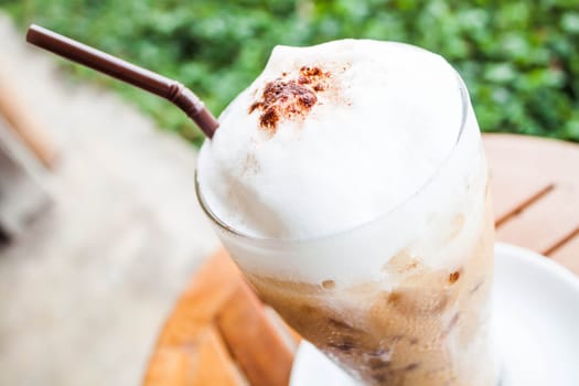 Refreshing glass of iced blended frappucino with milk foam