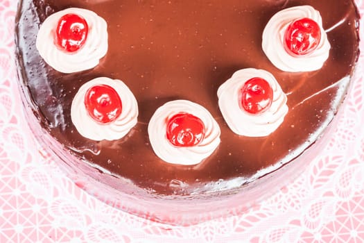 Top view of chocolate cake with red cherry
