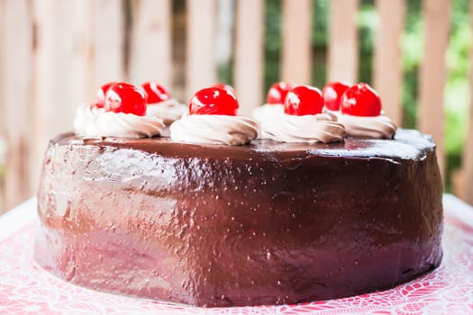 Fresh bake chocolate cake topped with cherry