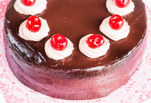 Home made chocolate cake with cherry and whipped cream