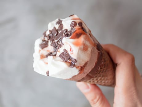 Melted ice cream in waffle cone in hand