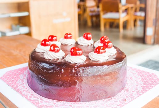 Chocolate cake with red cherry and whipped cream