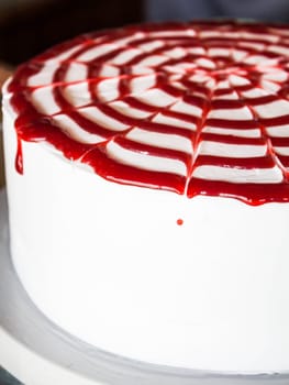 Raspberry sauce topped white whipped cream cake