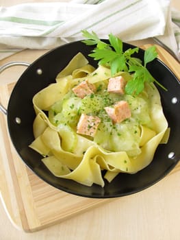 Noodles with wild salmon and cucumber vegetables in the wok