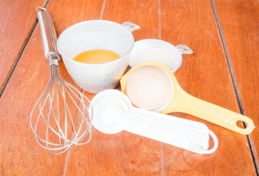 Step of bakery preparation with milk, butter, spoon, hand mixer and yolk separator