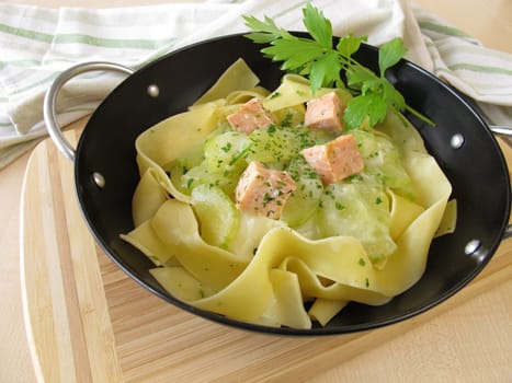 Noodles with wild salmon and cucumber vegetables in the wok