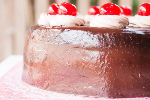 Delicious chocolate cake with cherry on top