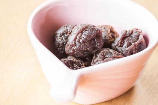 Close up delicious dried pink plum in cup