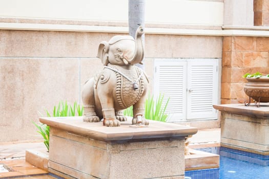 Elephant statue decorated beside tropical swimming pool