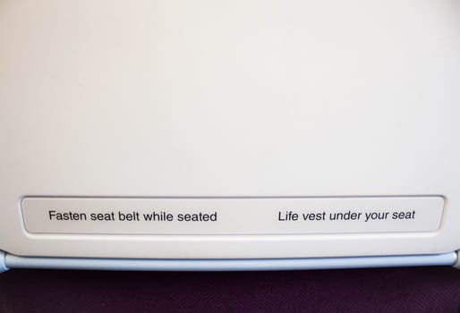 Airplane seat back with caution inform on flight