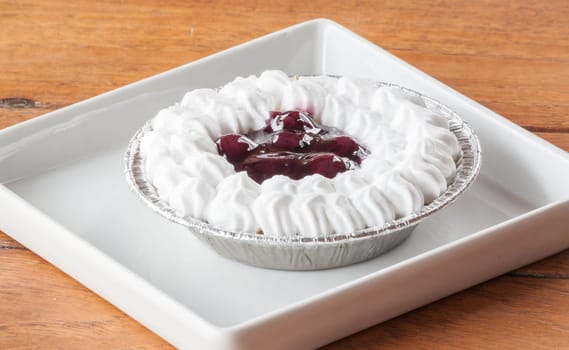 Blueberries cheesecake with whipped cream on a plate