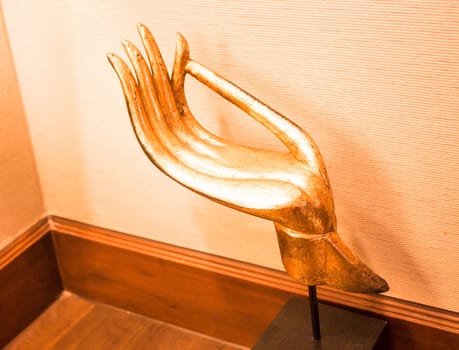 Gold wood carved hand sculpture on wood table
