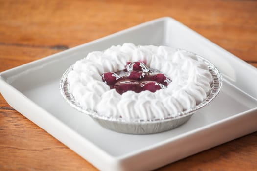 Blueberries cheese cupcake with whipped cream on a plate