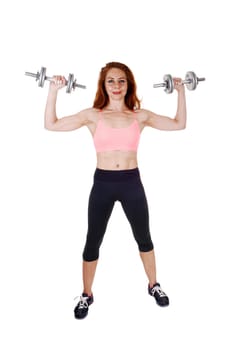A lovely slim women in black exercise pants and sports bra working.out with dumbbell's, isolated on white background..