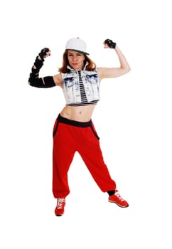 A lovely woman in red pants, jeans jacket and a hat standing with her arms.lifted up, isolated on white background..