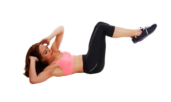 A slim pretty woman lying on the floor on her back doing stomach crunch,.isolated on white background..