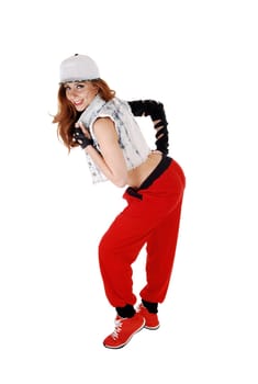 A lovely woman in red pants, jeans jacket and a hat standing in profile,.isolated on white background..