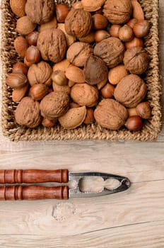 Nuts mix in a basket with a nutcracker