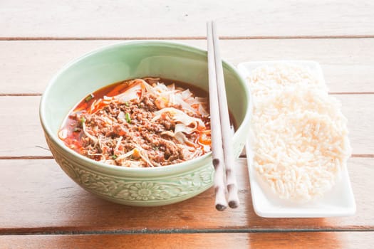 Traditional meal of spicy noodle and crispy rice cracker