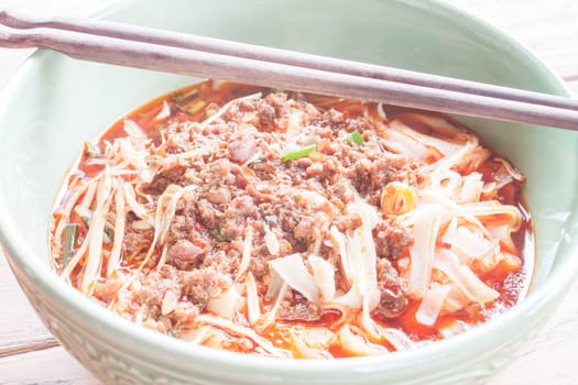 Spicy noodle soup with chopsticks up close