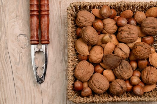 Nuts mix in a basket with a nutcracker