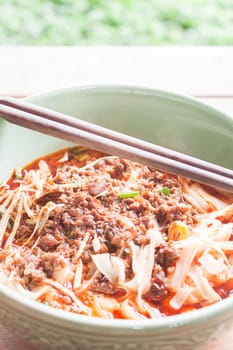 Spicy noodle in meat soup with chopsticks on table