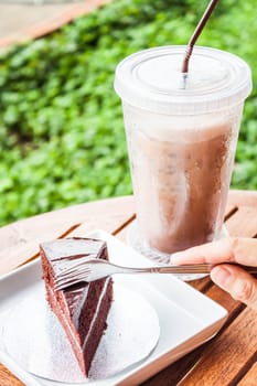 Custard chocolate cake and iced coffee serving on table