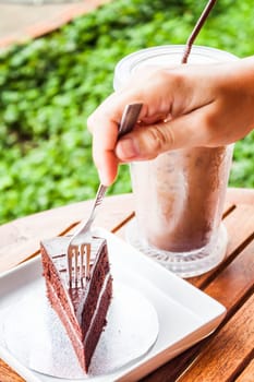 Soft chocolate cake and iced coffee serving on table