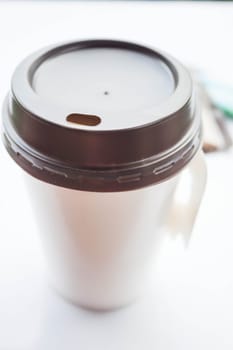 Coffee in paper cup with sugar packs on white background