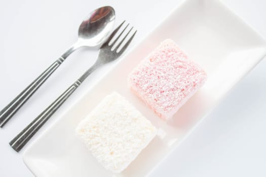 Set of pink and white lamington sponge cakes, stock photo