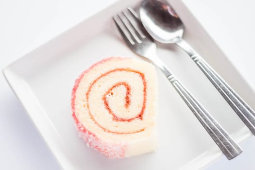 Strawberry jam roll cake with spoon and fork, stock photo