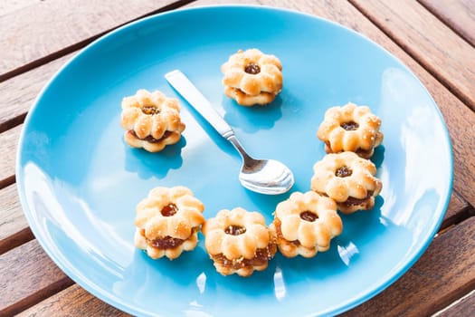 Smiling face of pineapple cookies on light blue dish, stock photo