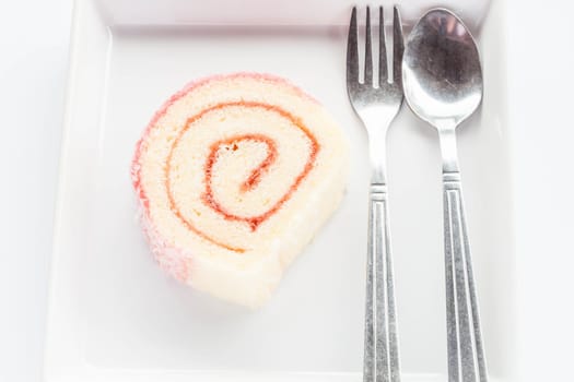 Strawberry jam lamington roll cake with spoon and fork, stock photo