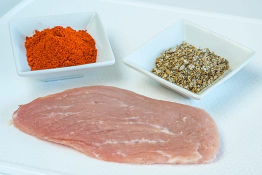raw schnitzel with spices