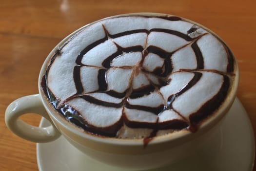 Cup of cappuccino coffee on wooden table