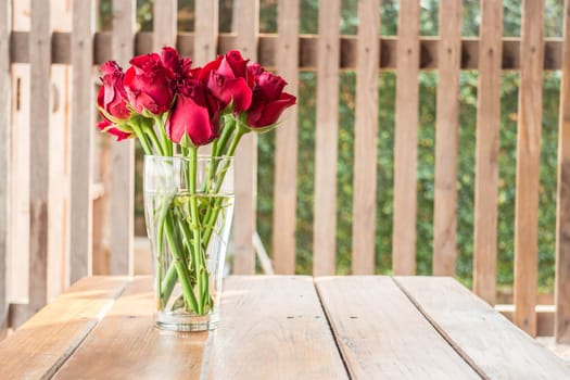 Group of red roses on wooden table, stock photo