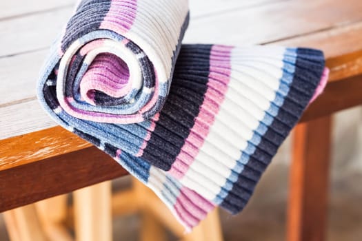 Knit striped scarf on wood table, stock photo