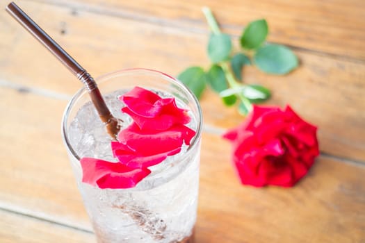 Red rose petals decorated iced pomegranate drink, stock photo