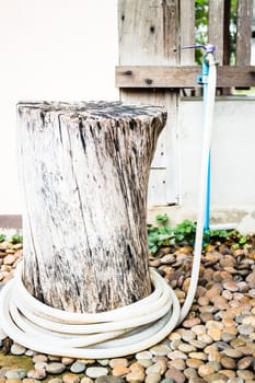 Rubber tube with aged faucet in garden, stock photo