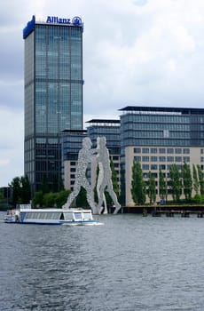 Berlin,Germany – June 16,2014: A passenger ship passes the artwork "Molecule man"" designed by Jonathan Borofsky on the River Spree on June 16,2014 in Berlin."