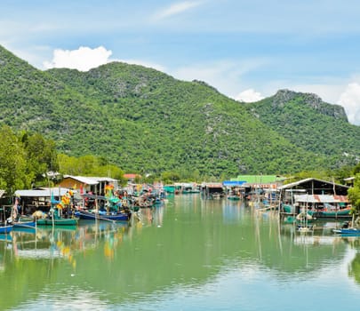Fishing village against limestone mountain, Thailand