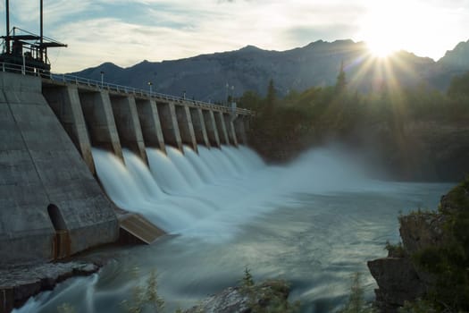 Wide shot time exposure of the spillway on the Kananaskis hydroelectric dam on the Bow River, with Canadian Rocky Mountains, Alberta, Canada