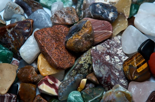 Close up of many different size, shape and colored tumbled stones