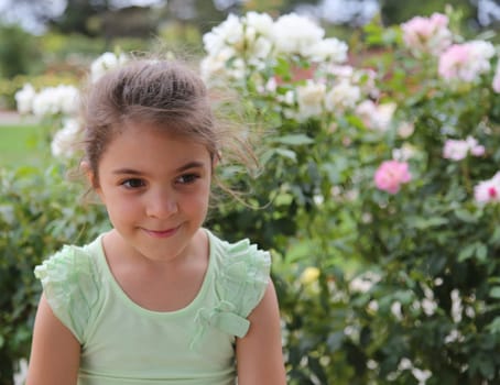 Beautiful girl with flower bushes in the background