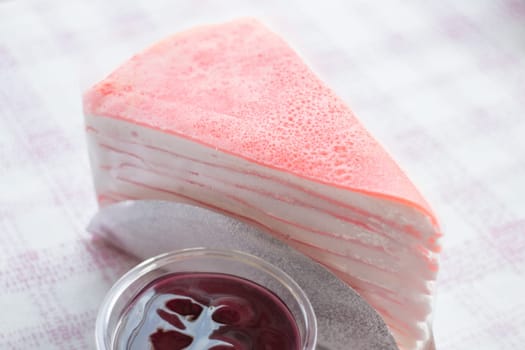 Close up pink crepe cake and blueberry sauce, stock photo