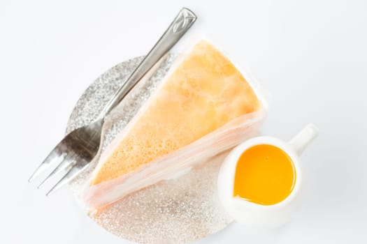 Crepe cake with orange sauce top view on white background, stock photo