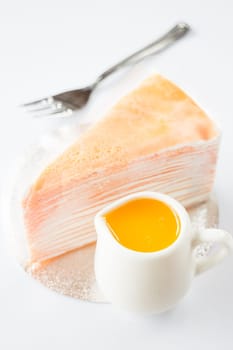 Orange whipped cream crepe cake on white background, stock photo