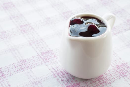 Ceramic pitcher of blueberry sauce, stock photo