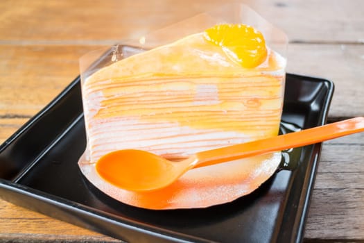 Delicious fresh orange crepe cake with sauce, stock photo